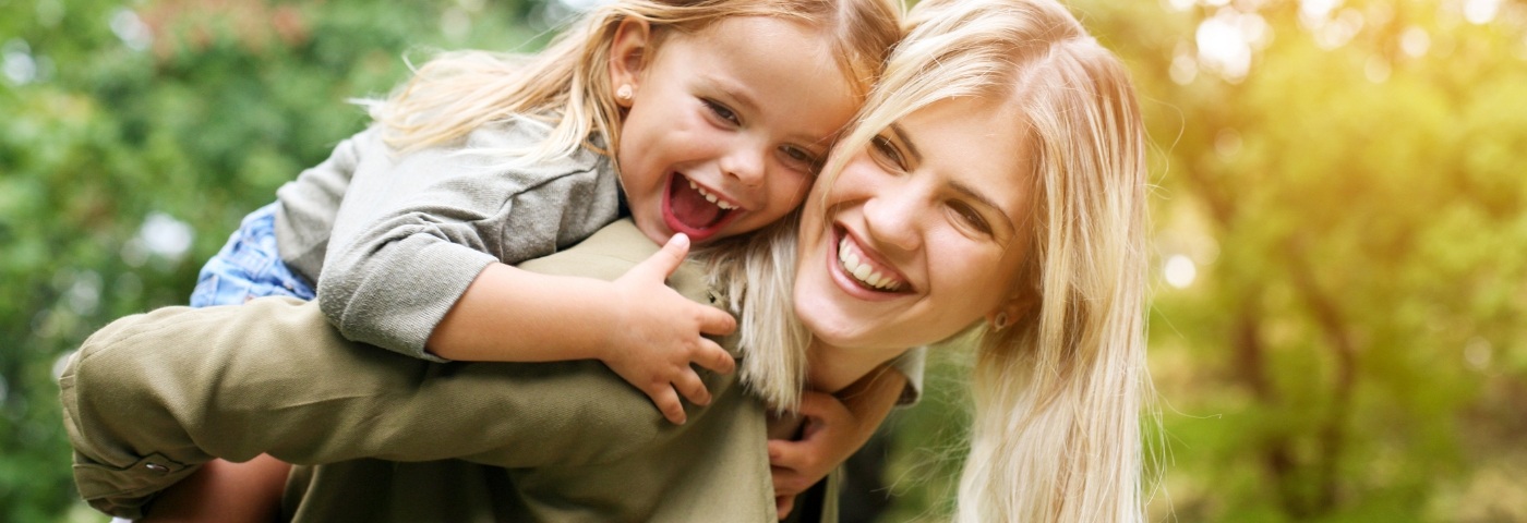 Woman giving her daughter a piggyback ride