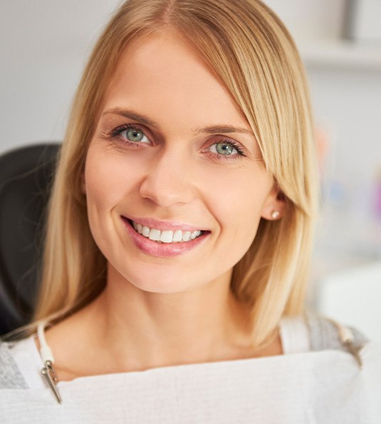 Blonde female dental patient smiling in chair