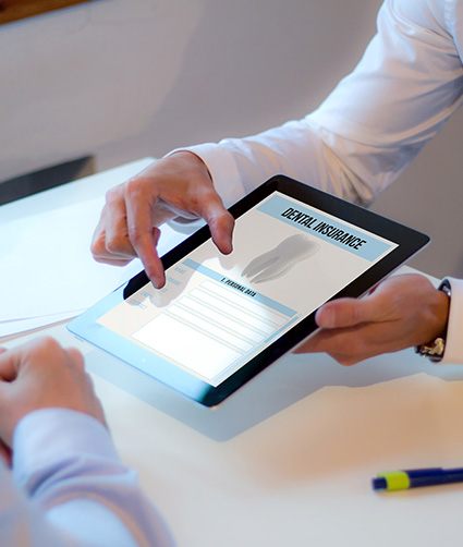 Showing patient a dental insurance form on a tablet