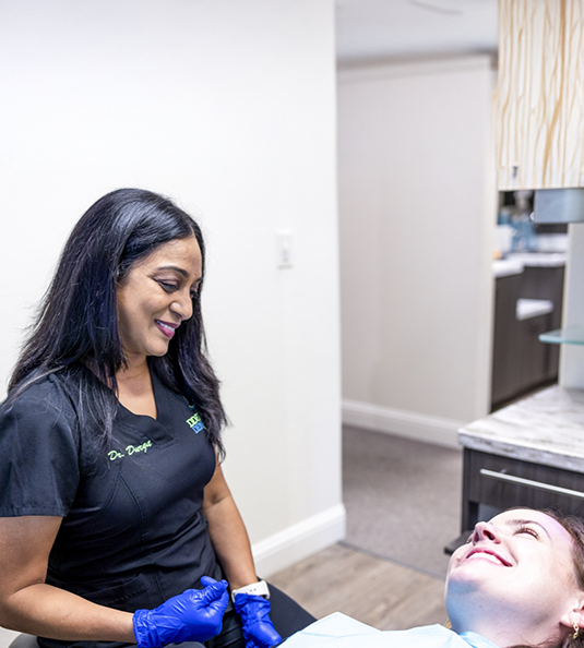 Female patient looking to side and talking to dentist