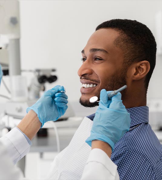 Side view of man sitting in dental chair smiling