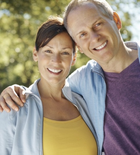 Man and woman standing outside smiling together