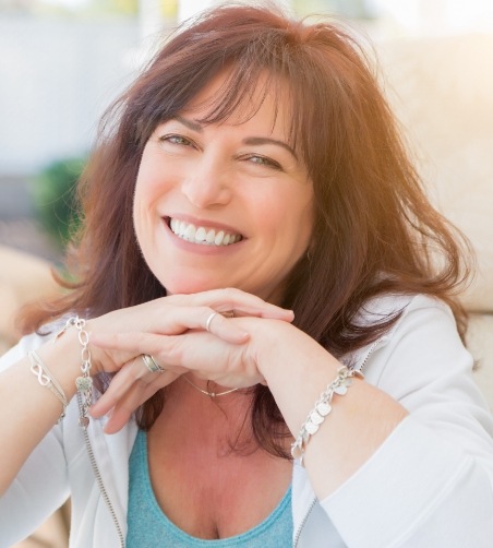 Woman with reddish hair sitting on couch and smiling