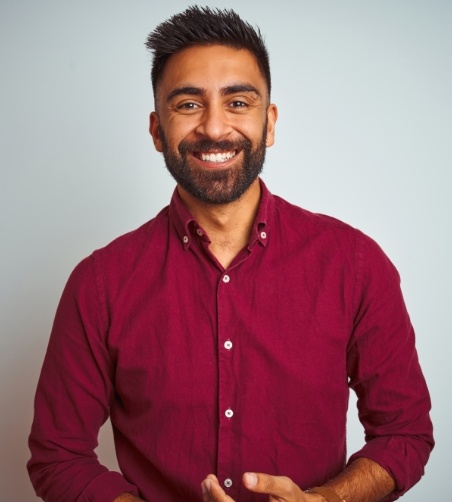 Man in maroon button up shirt smiling