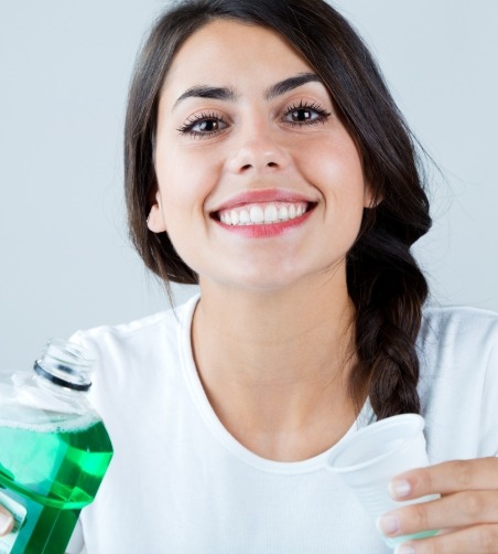 Woman holding cup and mouthwash