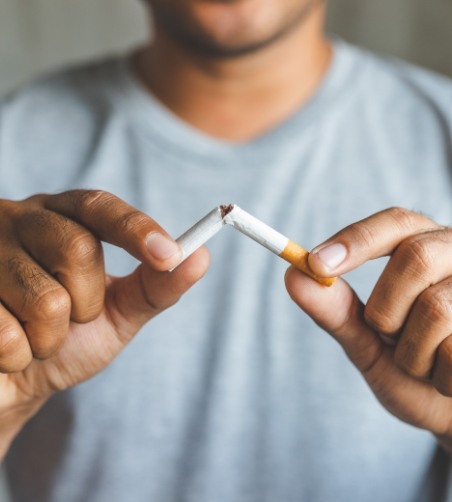 Close up of cigarette being snapped in half