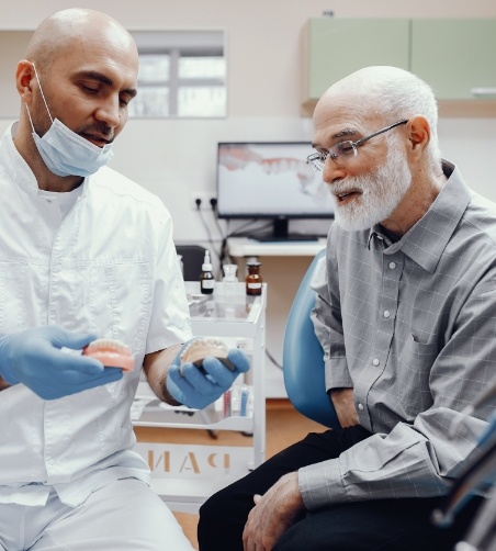 Dentist showing patient model teeth