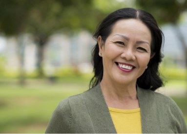 Woman in yellow shirt and jacket smiling