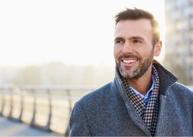 Man in jacket taking walk outside smiling