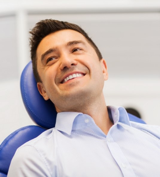 Male dental patient in button up shirt smiling