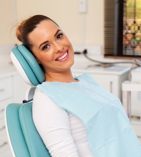 Woman sitting in dental chair and smiling