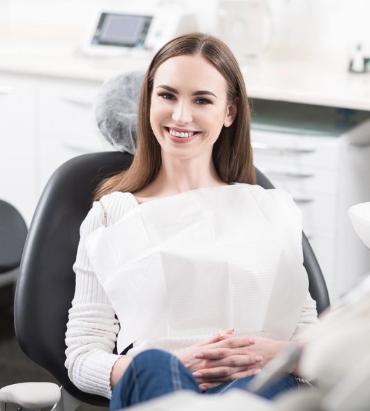 Woman sitting in dental chair and smiling