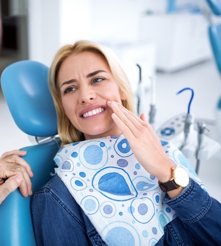 Blonde woman in dental chair with tooth pain