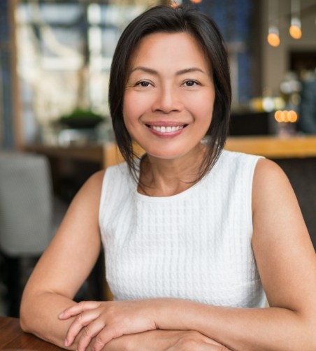 Woman in white sweater sitting and smiling