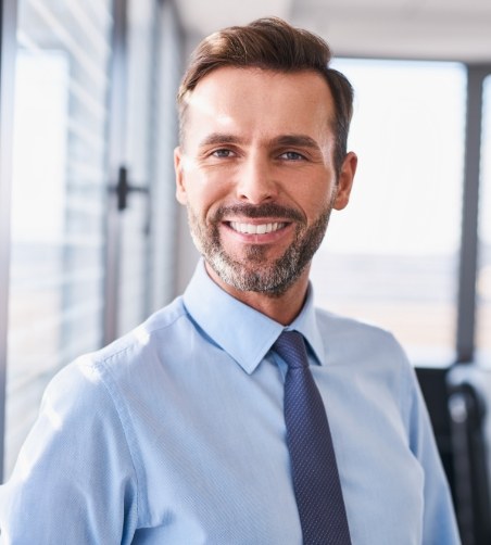 Man with tie standing and smiling