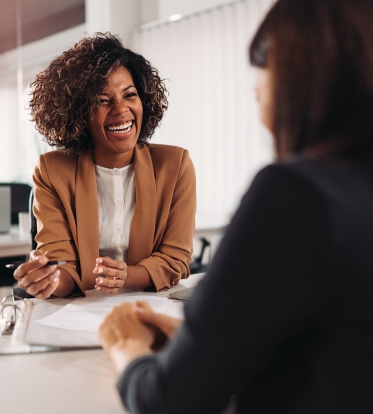 Woman smiling at another woman across a table