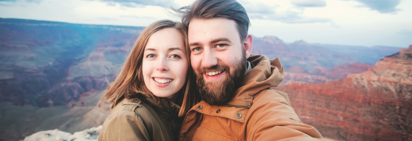 Man and woman taking selfie in front of canyon