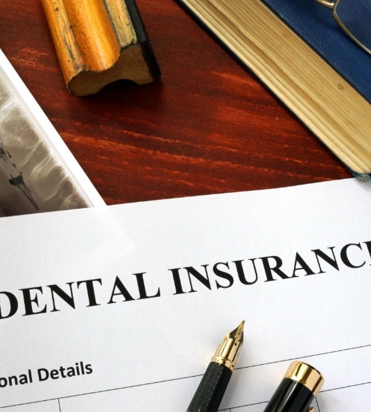 Dental insurance form on a messy desk