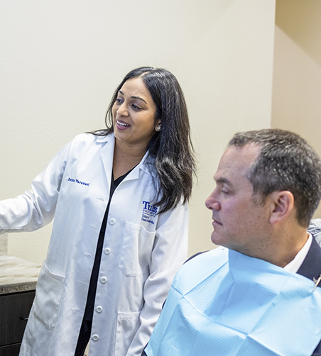 Male patient in chair with dentist in Carrollton sitting nearby