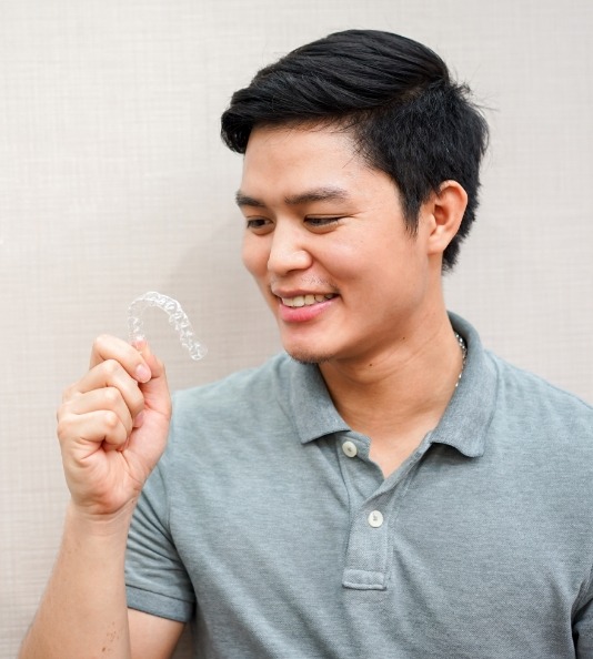 Man in collared shirt looking at clear aligner