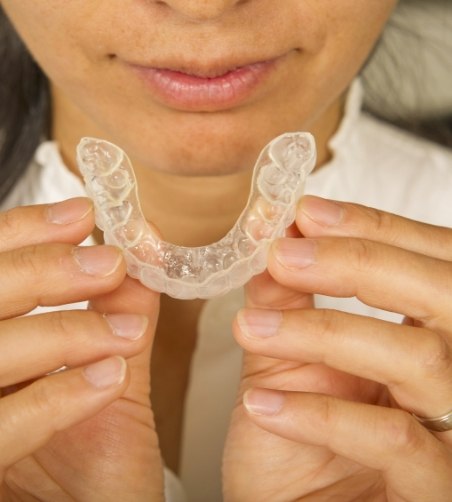 Close up of patient holding a clear aligner