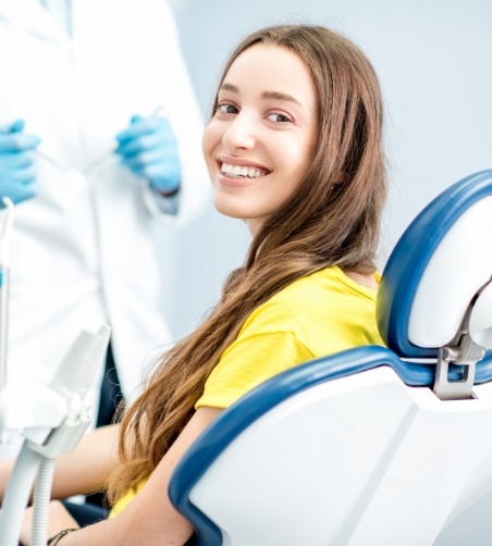 Female patient in yellow shirt looking back and smiling