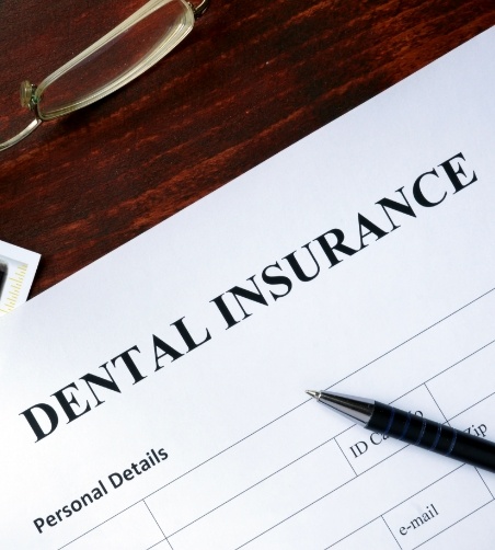 Dental insurance form with pen and glasses