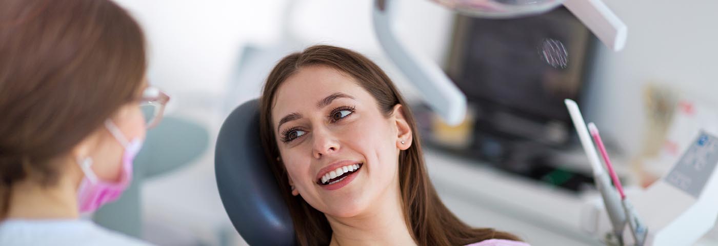 Close up of female patient talking to dentist