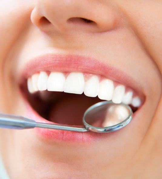 Close up of dental mirror examining teeth