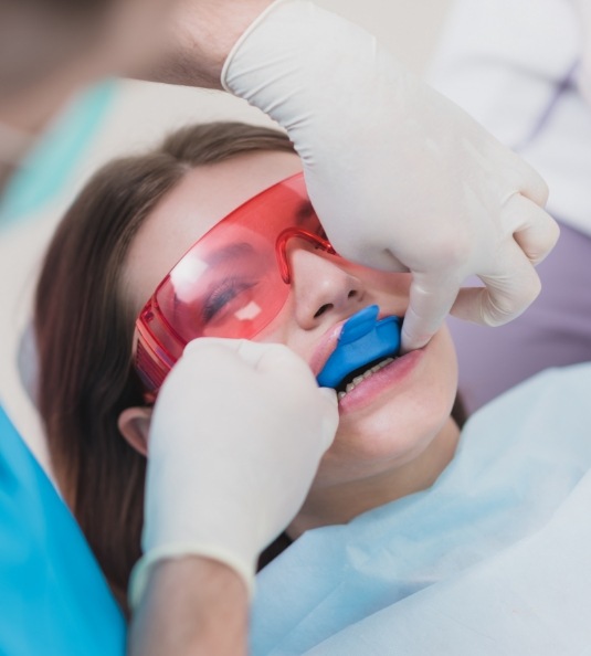 Little girl receiving fluoride treatment from dentist