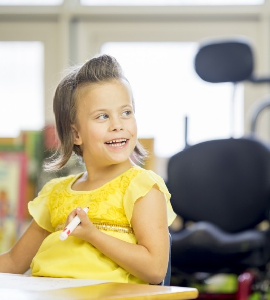 Girl in yellow shirt smiling in dental office