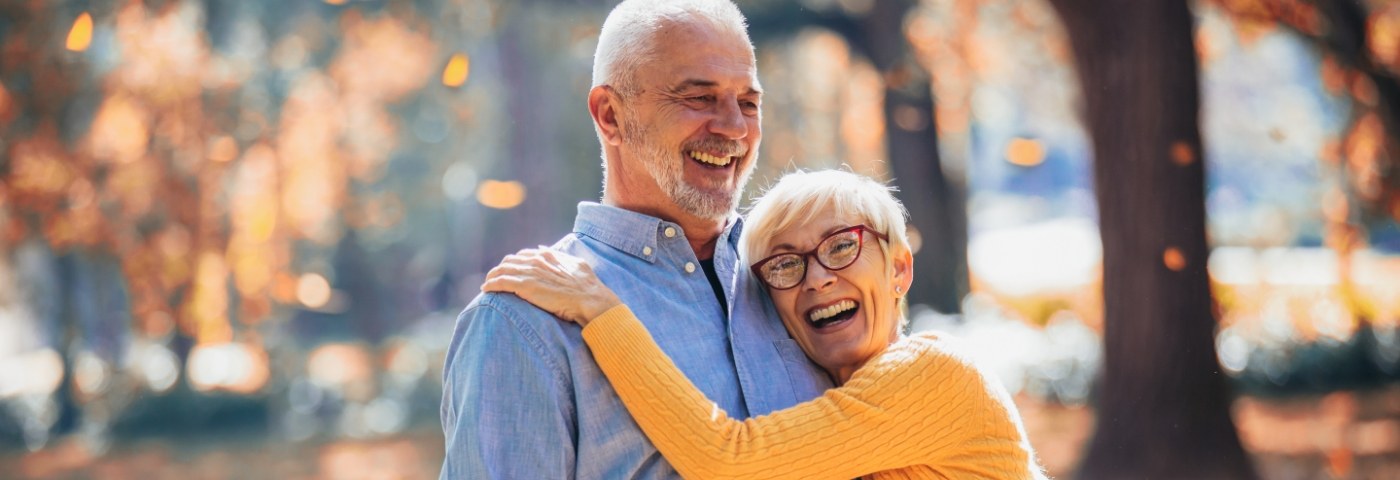 Senior man being hugged by senior woman