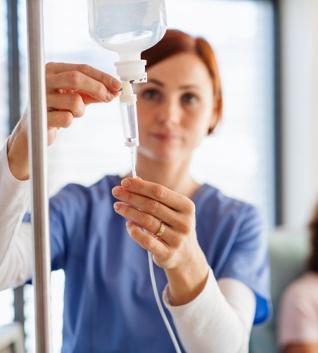 Female dentist hooking up an IV drip