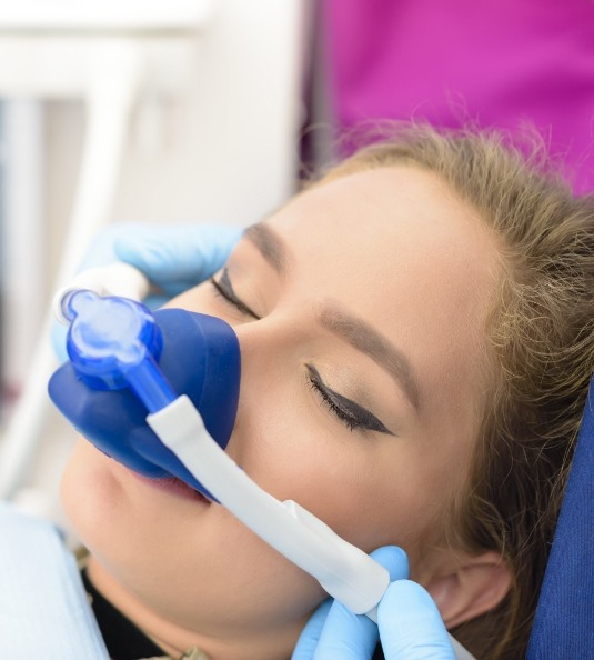 Woman sitting back in chair with mask for nitrous oxide sedation