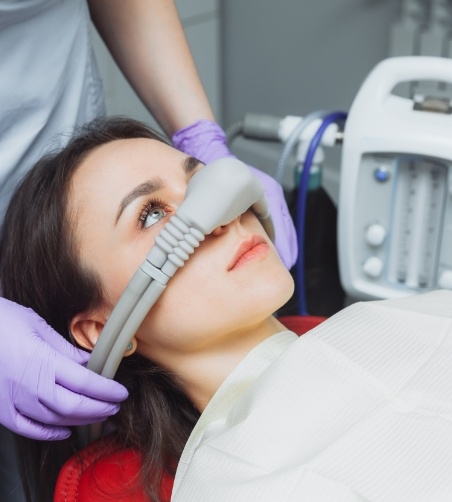 Woman looking up while having mask placed over nose