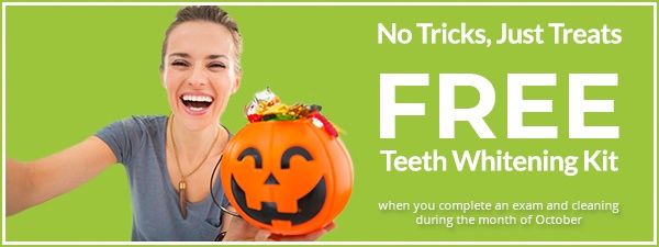 Smiling woman holding Halloween bucket full of candy