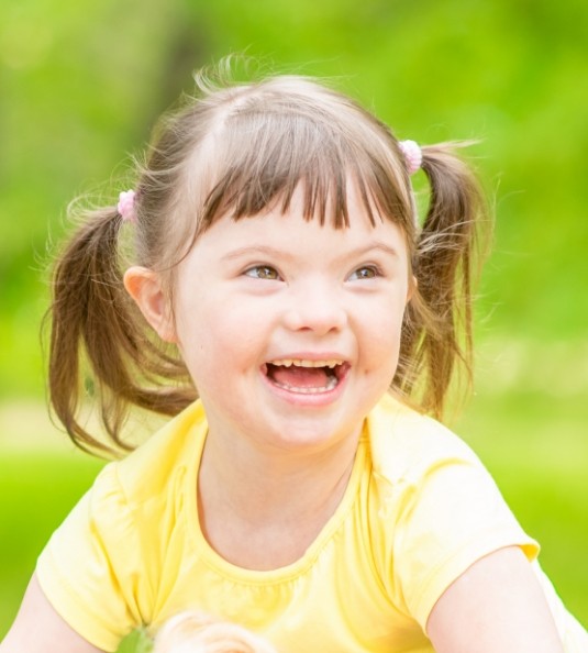 Close up of smiling little girl with yellow shirt