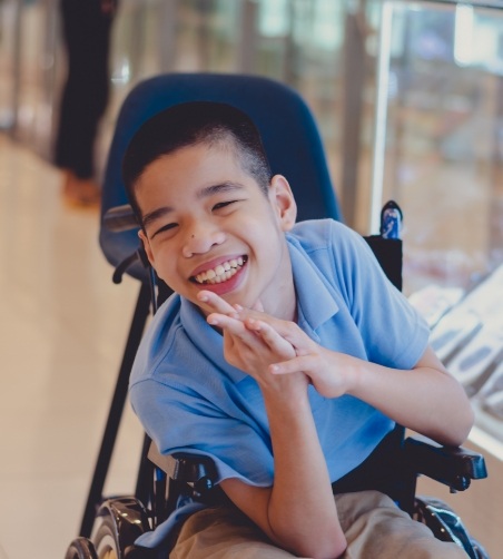 Little boy sitting in wheelchair and smiling