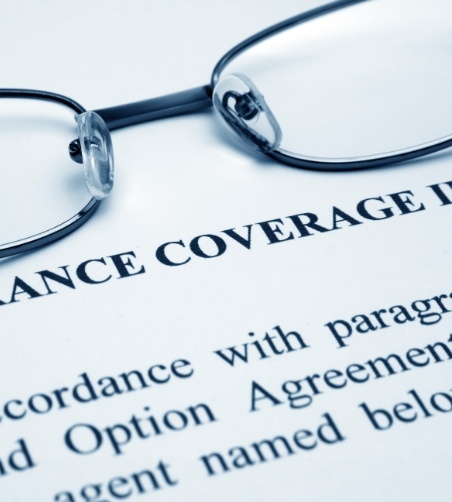 Close up of glasses sitting on insurance coverage form