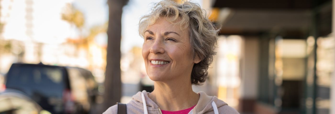 Woman walking down street and smiling