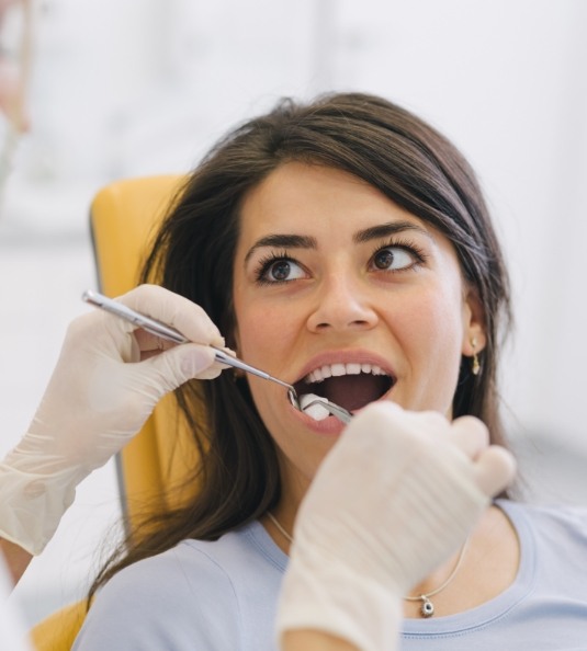 Woman holding mouth open for dentist