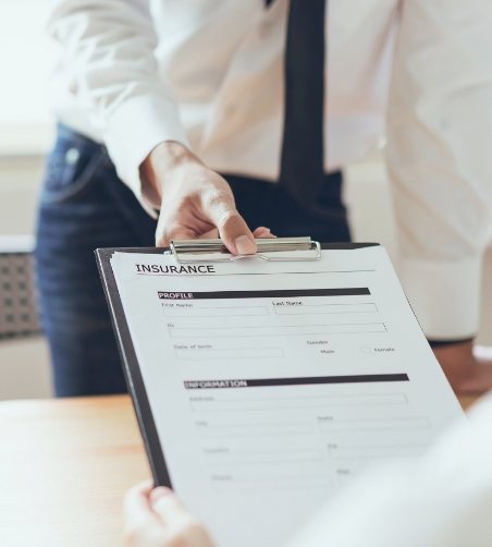 Handing man with tie clipboard with dental insurance form